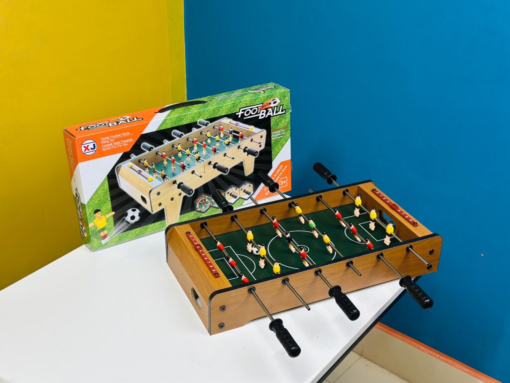 Wooden tabletop football game for kids with mini players and handles, perfect for indoor fun and family play.